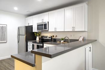 A kitchen with white cabinets and stainless steel appliances